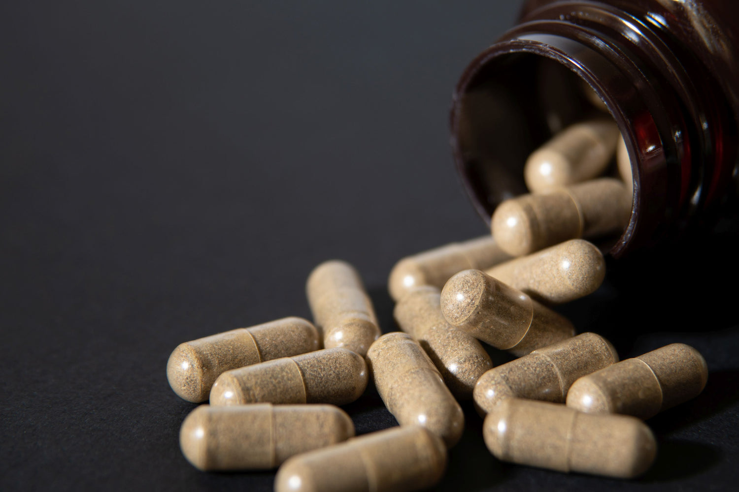 herbal capsules poured from a jar
