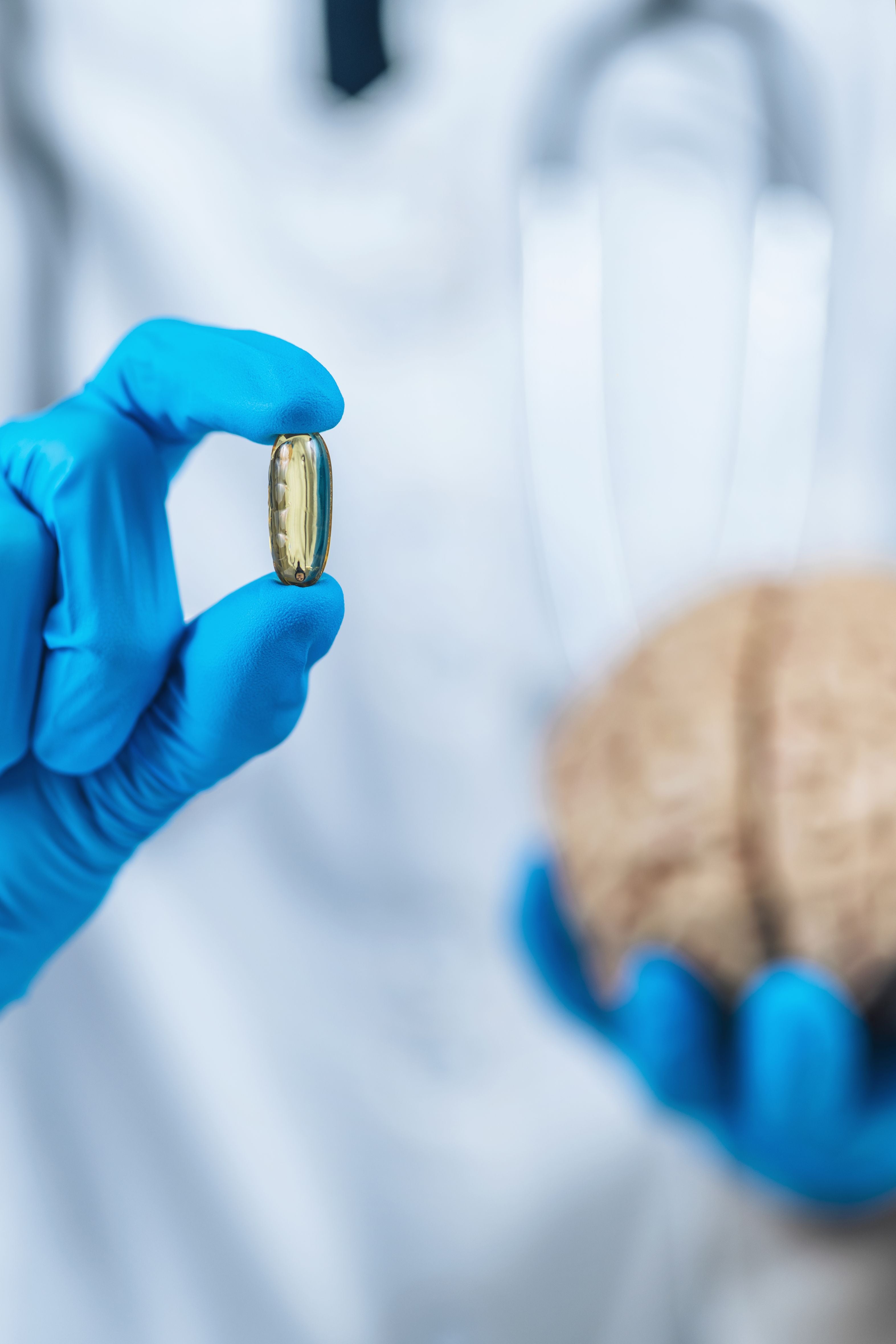 brain health supplements hand holding pill and a brain